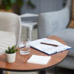 Insurance and benefits paperwork on a table next to a cup of tea
