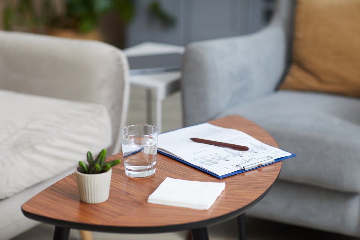 Insurance and benefits paperwork on a table next to a cup of tea