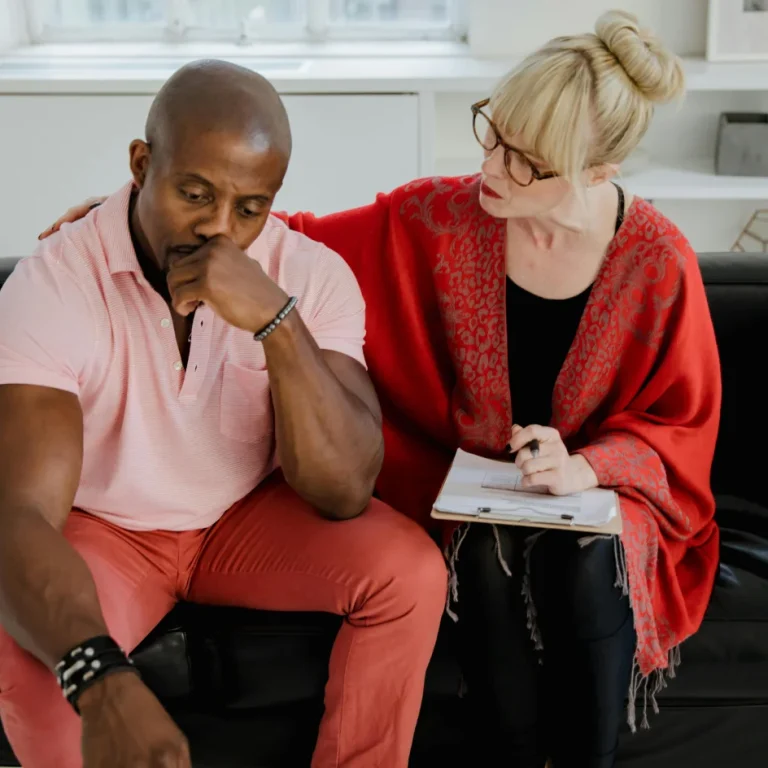 A couple sitting apart on a couch after an argument